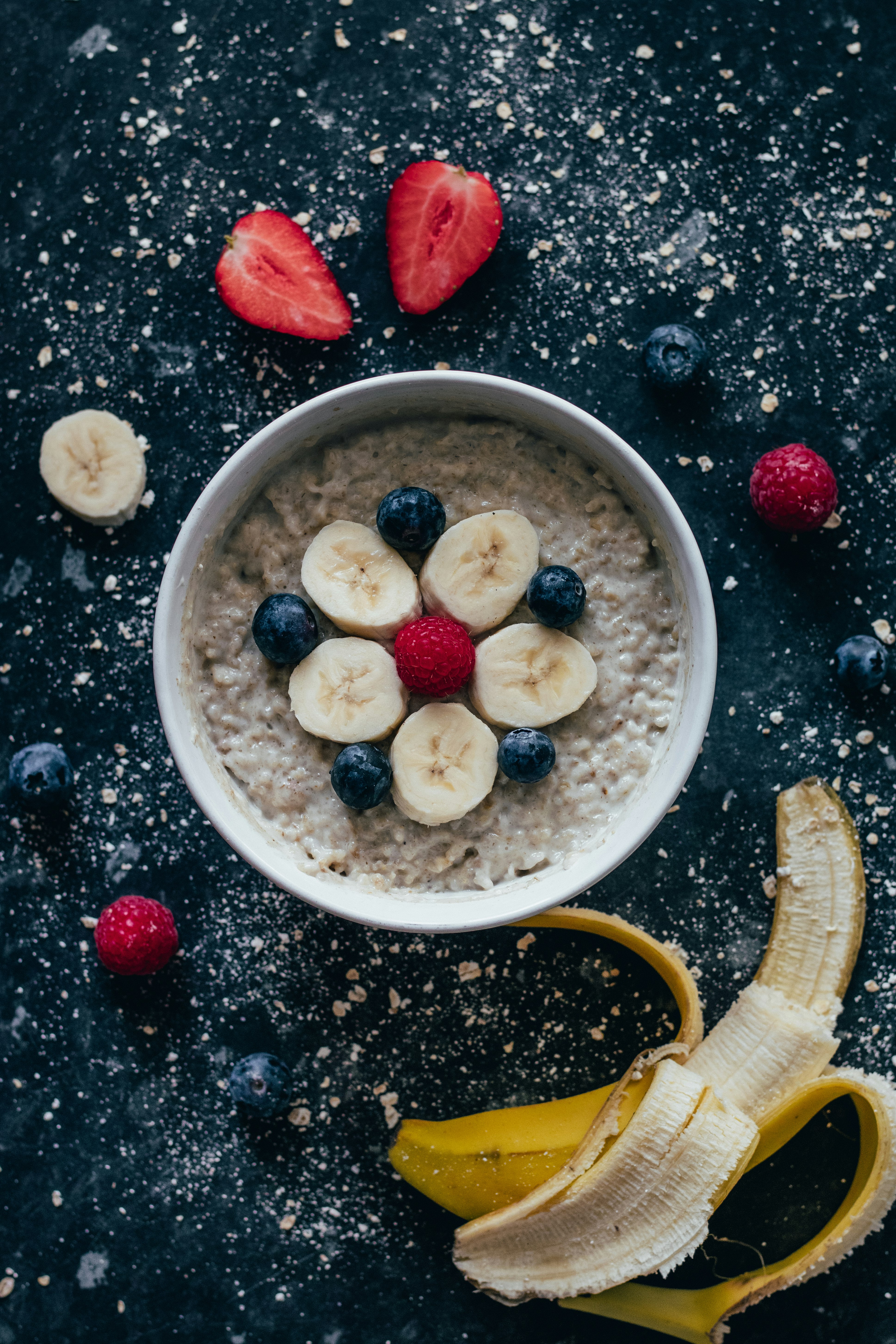 white ceramic bowl with sliced banana and red strawberry